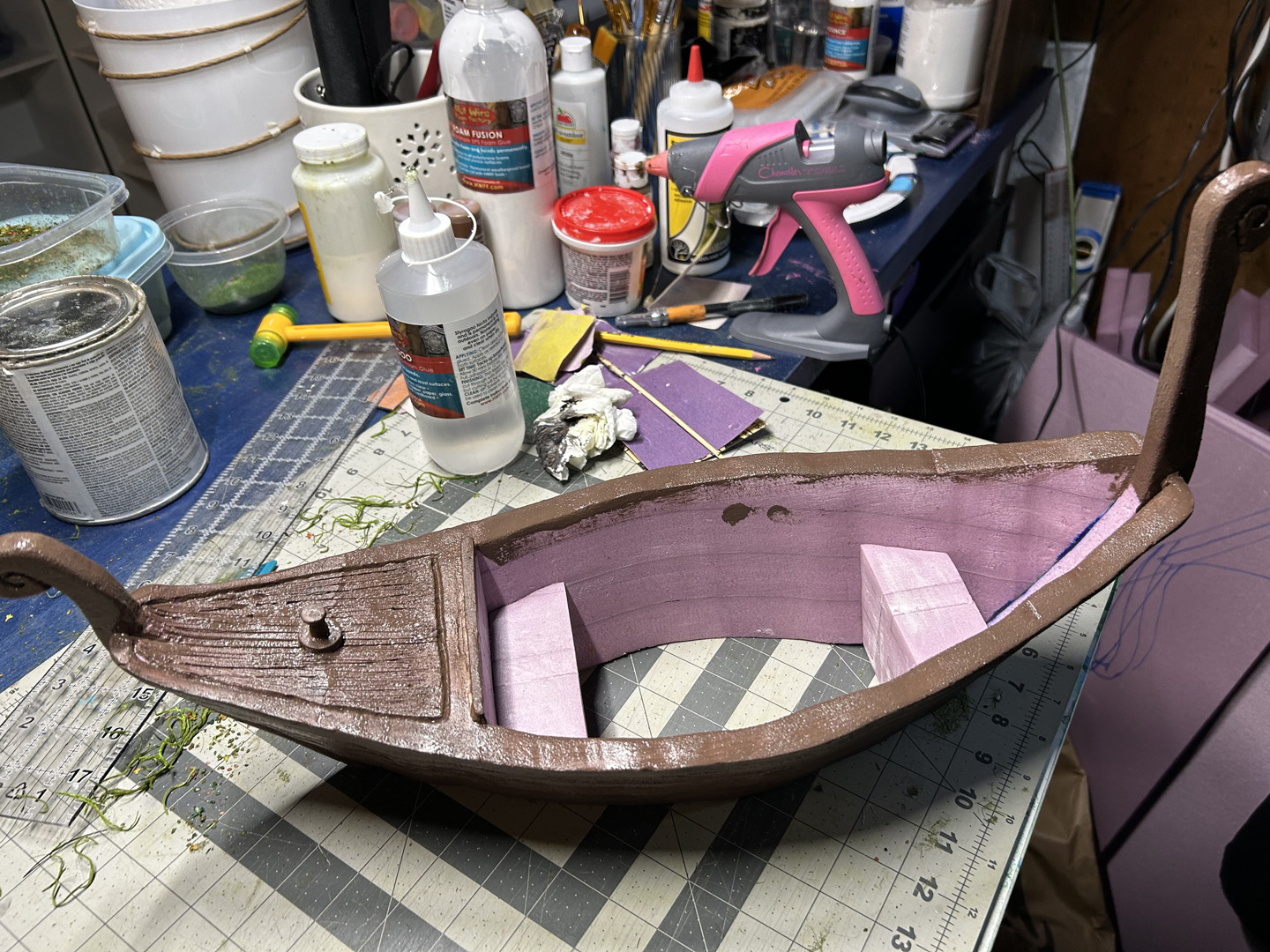painting a small decorative boat out of pink xps foam