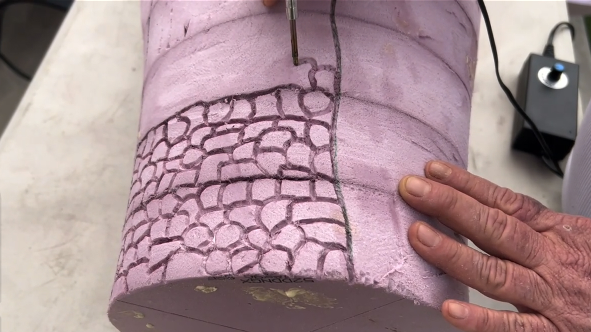 engraving a brick texture into a mini replica of rapunzel's tower